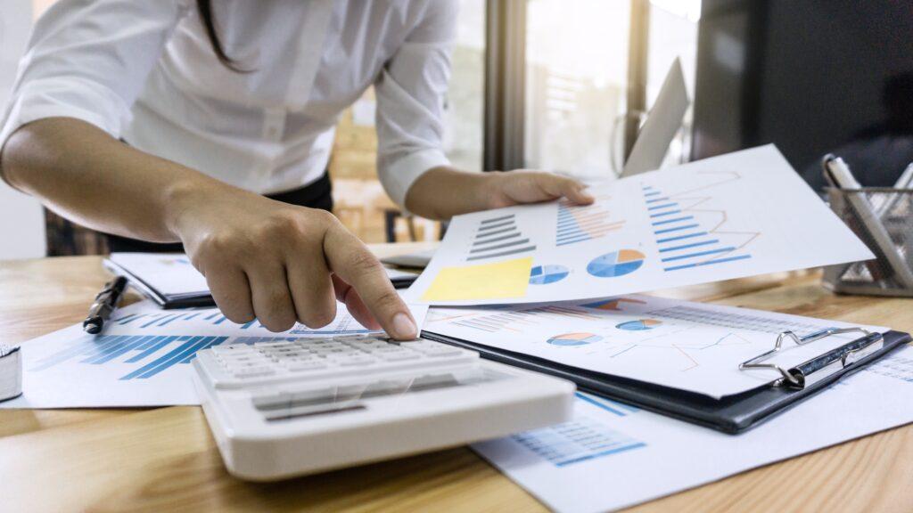 Business woman accountant working and calculating financial data on graph documents